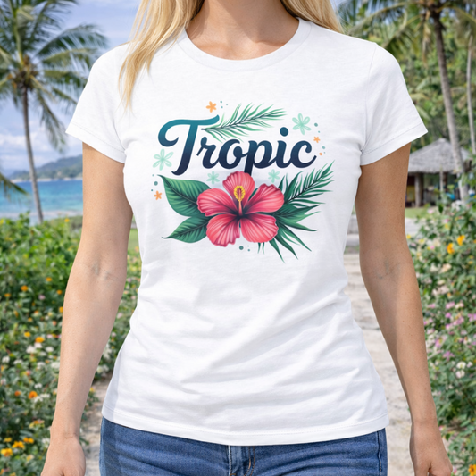 Person wearing a white t-shirt with tropical design of greenery and hibiscus and text Tropic. 