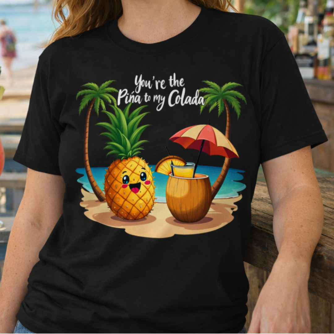 Woman wearing a black t-shirt with a pineapple and umbrella design with text You're the Pina to my Colada.