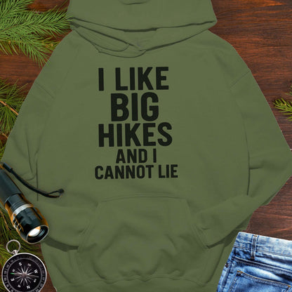 Green hoodie with 'I LIKE BIG HIKES AND I CANNOT LIE' text on a wooden surface with hiking accessories.