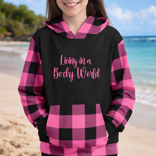 Person wearing a black and pink gingham checkered hoodie with text 'Living in a Beachy World'.