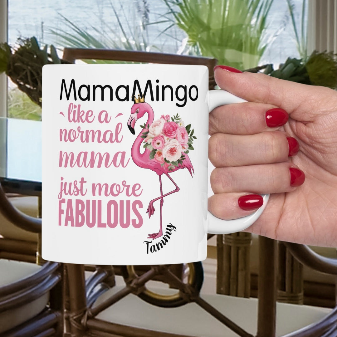 Mug with flamingo design and text held by a hand with red nails.