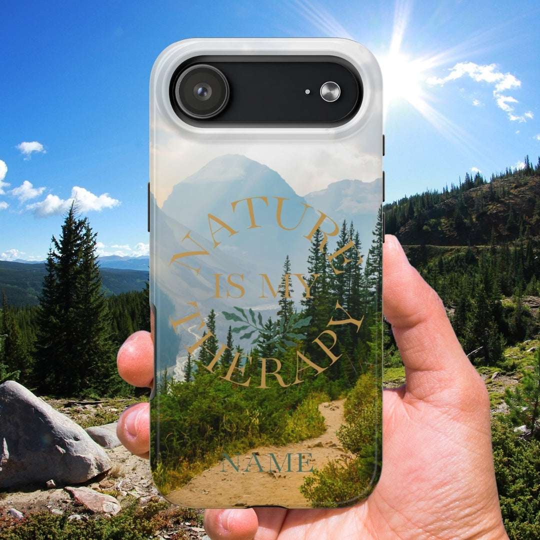 Phone case with nature design held in front of a scenic mountain landscape