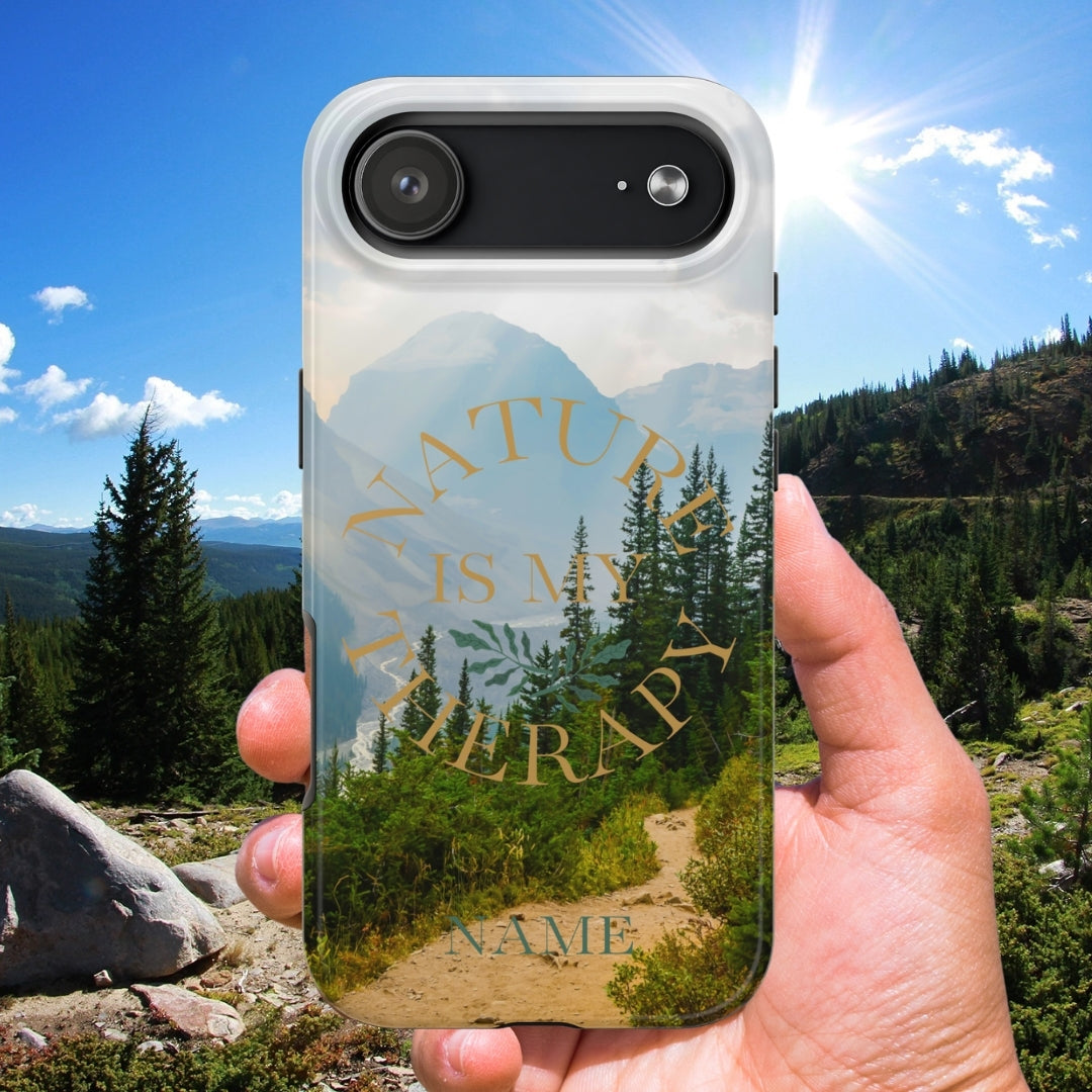 Phone case with nature design held in front of a scenic mountain landscape