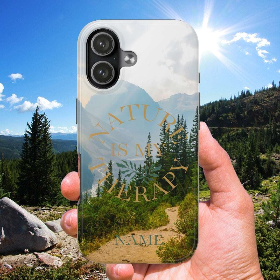 Phone case with nature design held in front of a scenic mountain landscape
