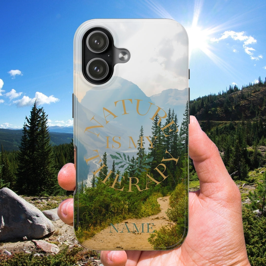 Phone case with nature design held in front of a scenic mountain landscape