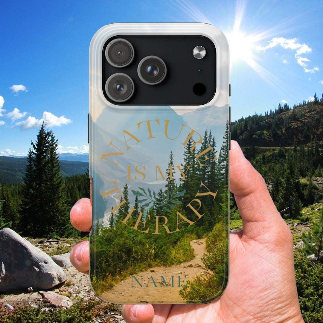 Phone case with 'Nature is my Therapy' design held in front of a scenic landscape.
