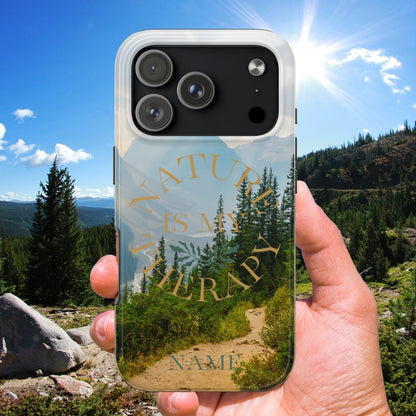 Phone case with 'Nature is my Therapy' design held in front of a scenic landscape.