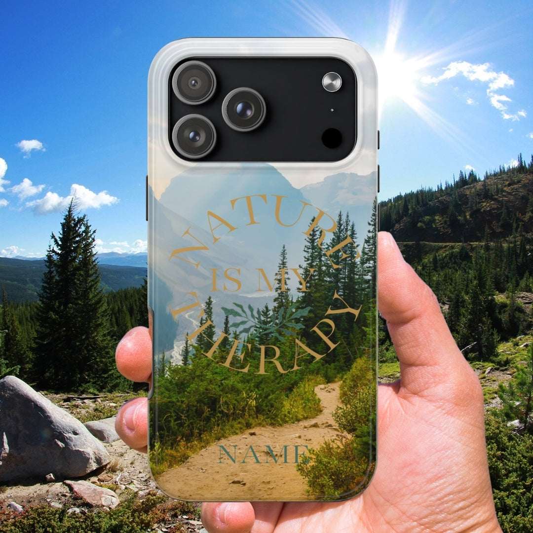 Phone case with nature design held in front of a scenic landscape