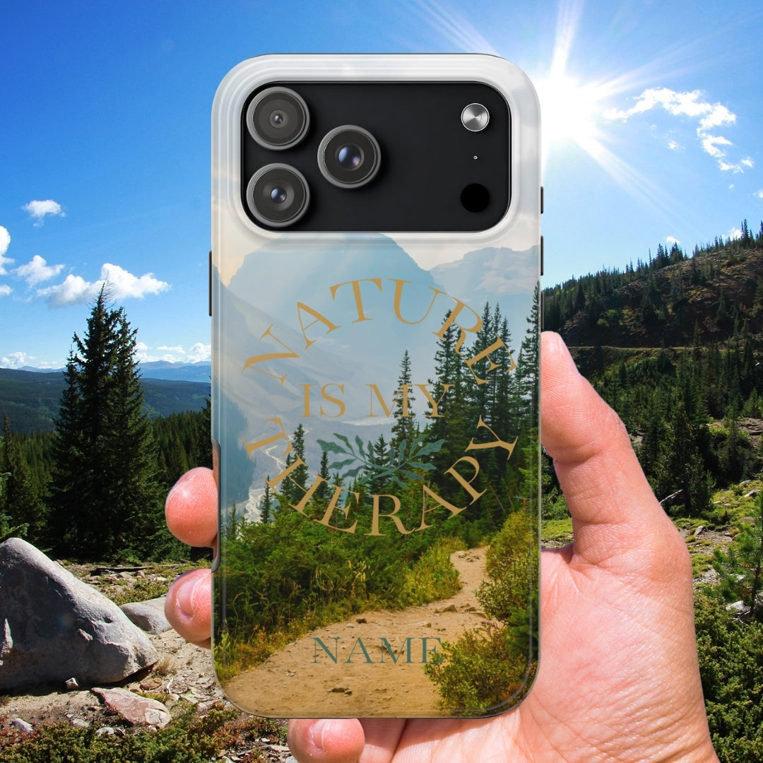 Phone case with nature design held in front of a scenic landscape