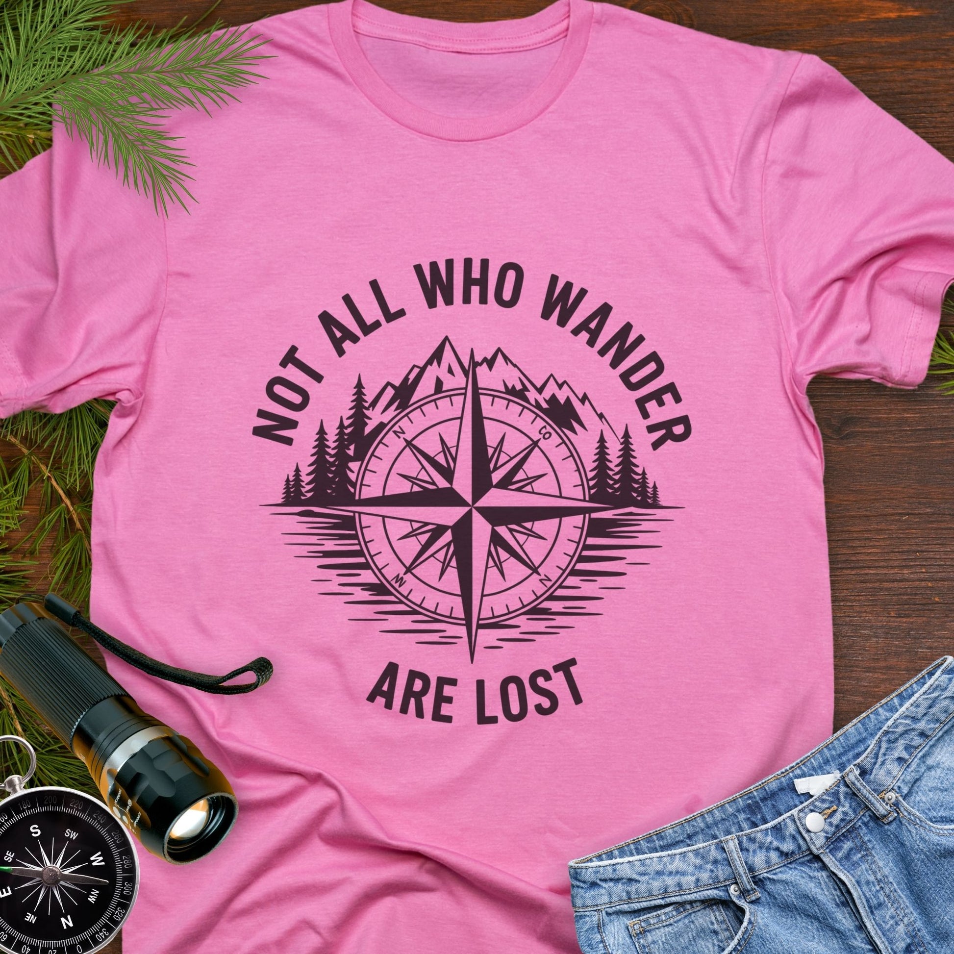 Azalea  T-shirt with a mountain range and lake with a compass overlay that says Not All Who Wander are Lost. 