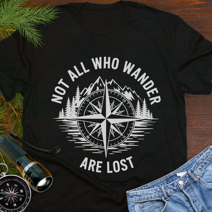 Black  T-shirt with a mountain range and lake with a compass overlay that says Not All Who Wander are Lost. 