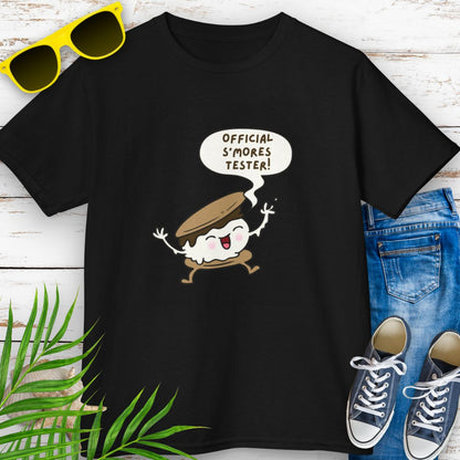 Black child’s t-shirt with "Official S’mores Tester"  speech bubble and cartoon s'more– fun campfire-themed shirt for kids.
