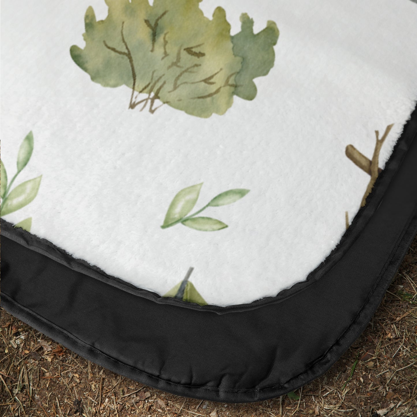 Close-up of a outdoor blanket with green leaf patterns with a waterproof backing.