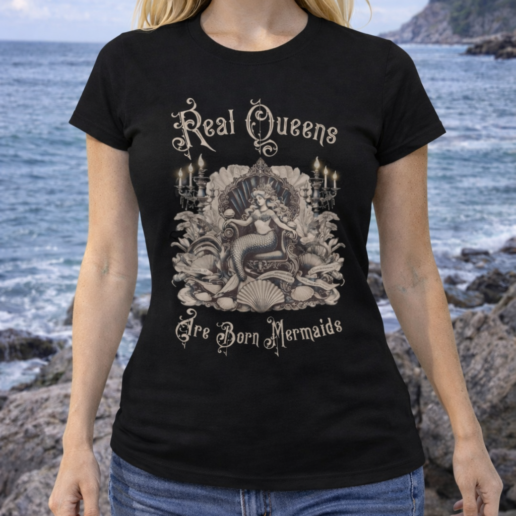 Woman wearing a black t-shirt with a vintage queen mermaid sitting on a throne and text, Real Queens Are Born Mermaids.