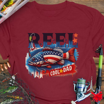 Cardinal Red patriotic fishing T-shirt with red, white, and blue design and the phrase “Reel Cool Dad”.