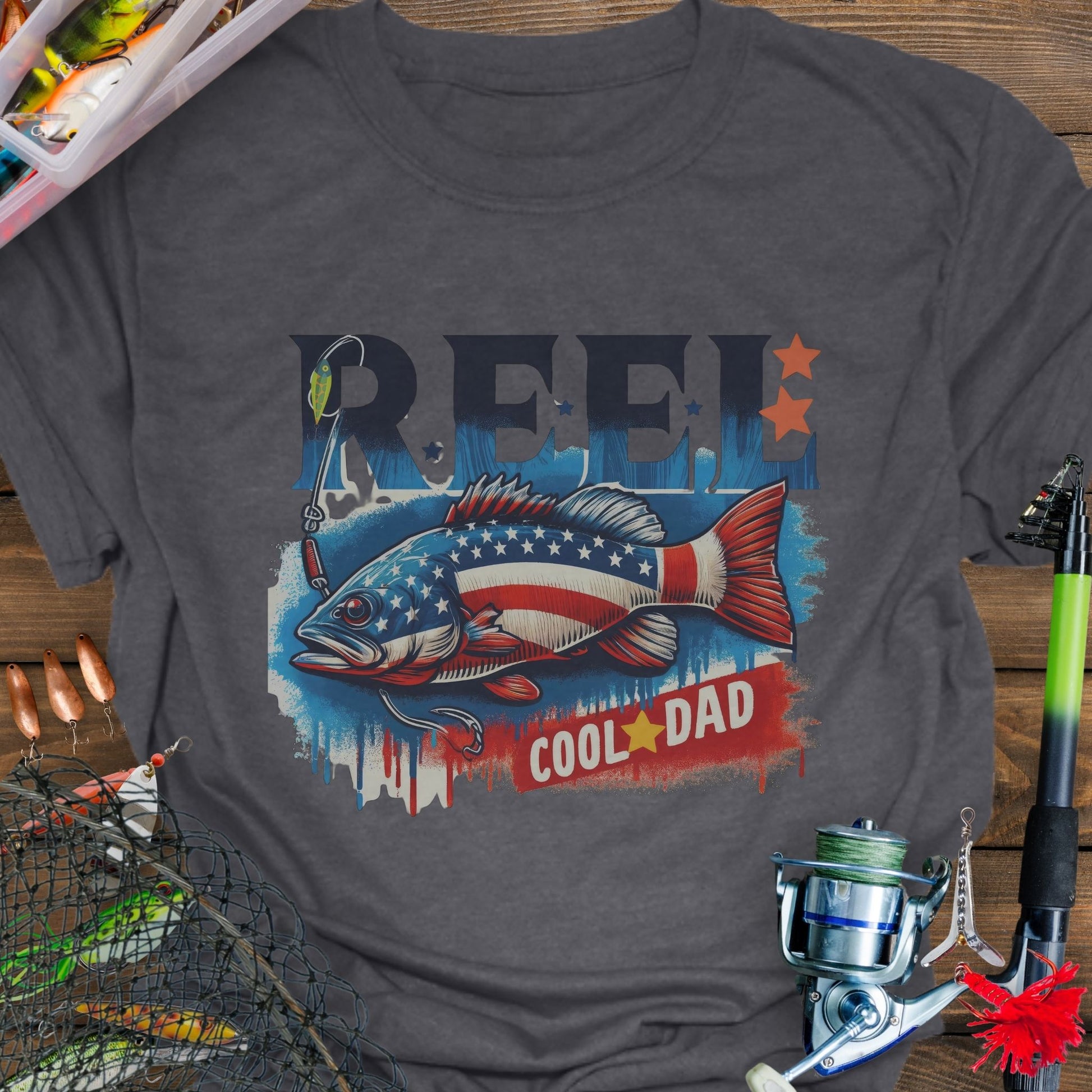 Dark Heather patriotic fishing T-shirt with red, white, and blue design and the phrase “Reel Cool Dad”.