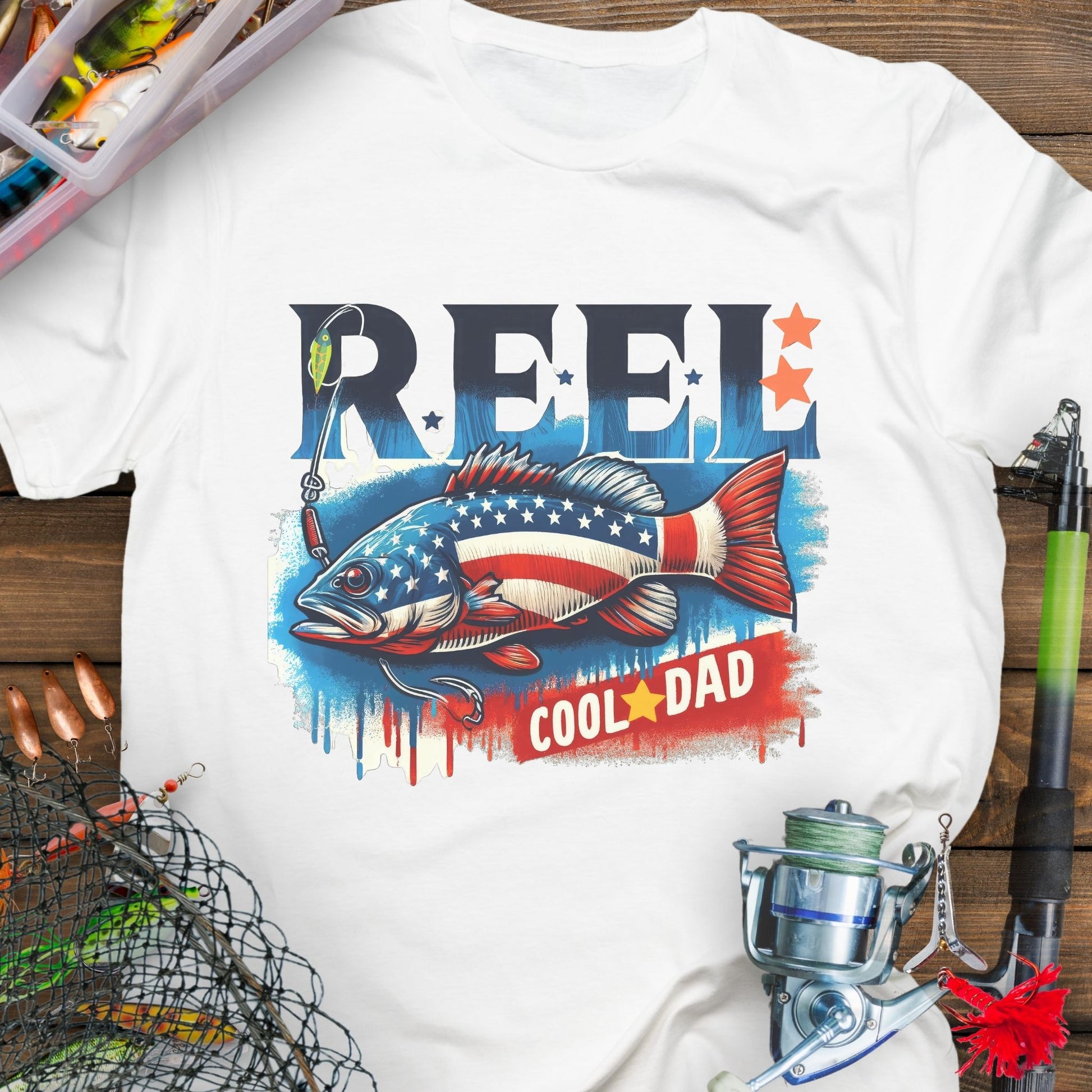 White patriotic fishing T-shirt with red, white, and blue design and the phrase “Reel Cool Dad”.