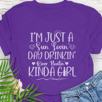 Purple Unisex t-shirt with the phrase "Sun-loving, Day-drinking, River-floating Kind of Girl" printed on the front with embellishments, featuring a relaxed fit and soft cotton fabric.