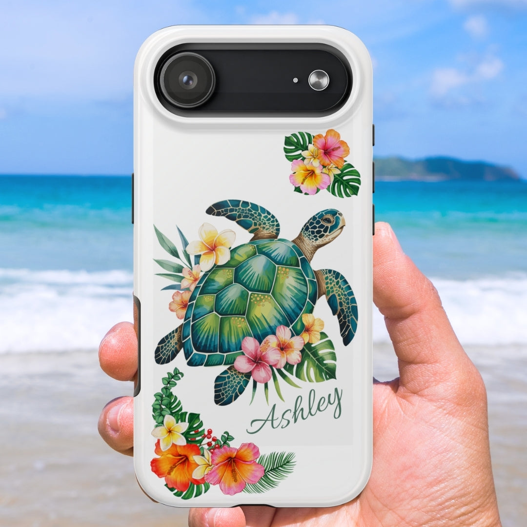 iPhone 17 air phone case with a sea turtle design with hibiscus flowers and can be personalized held against a beach background.