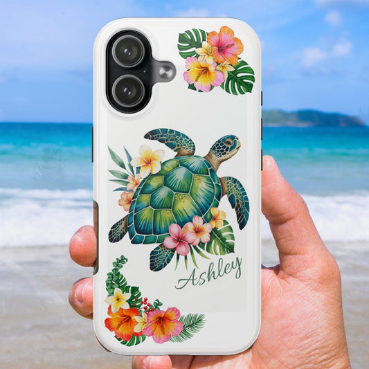 iPhone 17 phone case with a sea turtle design with hibiscus flowers and can be personalized held against a beach background.