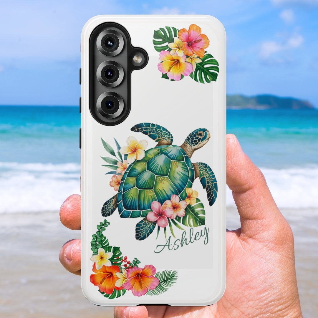 Samsung 25 phone case with a sea turtle design with hibiscus flowers and can be personalized held against a beach background.