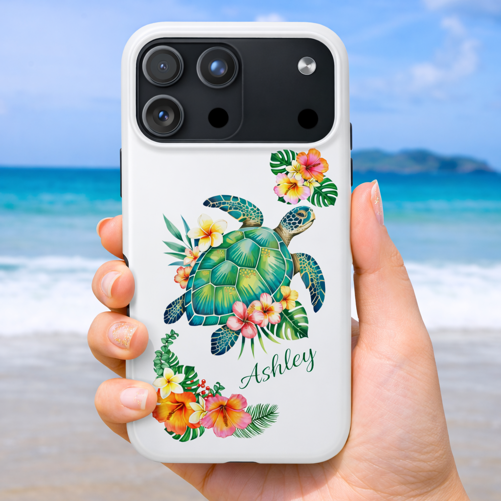 iPhone 17 Pro phone case with a sea turtle design with hibiscus flowers and can be personalized held against a beach background.