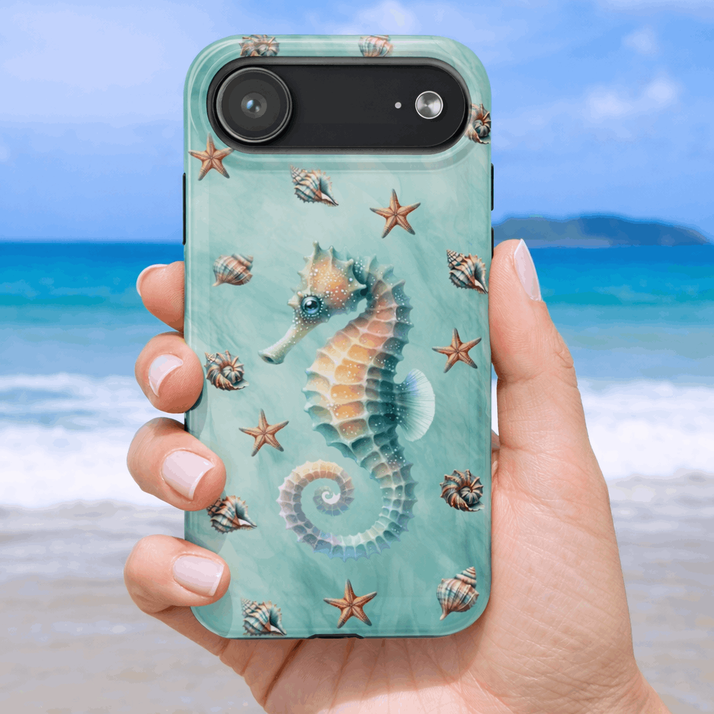 iPhone 17 air phone case with seahorse and shell design held by a hand on a beach background