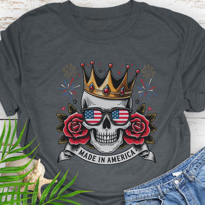 Dark Heather T-shirt with  a skull wearing a crown and American flag sunglasses, surrounded by red roses with fireworks in the background and a "Made in America" banner.