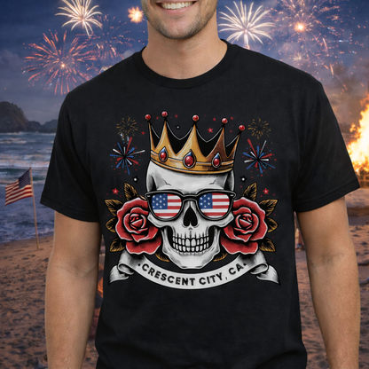 Person wearing a black t-shirt with a skull wearing American flag sunglasses, roses, and a crown with a Crescent City, CA banner below.