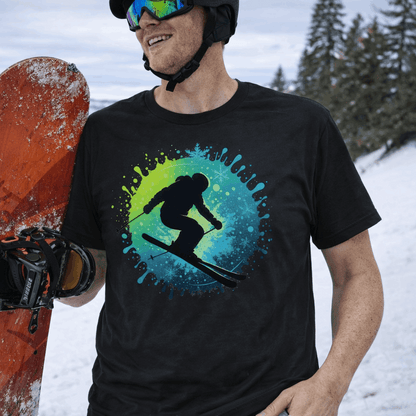 Person holding a snowboard with a black t-shirt with a bright splash design with a silhouette of a surfboarder.