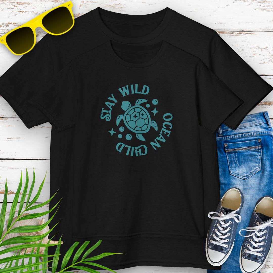 Black kids ocean-themed T-shirt with sea turtle design and coastal vibes with phrase Stay Wild Ocean Child around sea turtle.