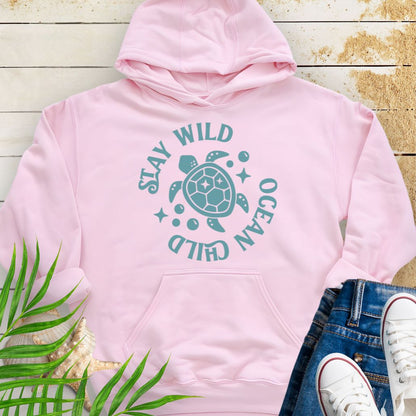 Pink sea turtle lover hoodie with ocean-inspired Stay Wild Ocean Child phrase around a sea turtle.