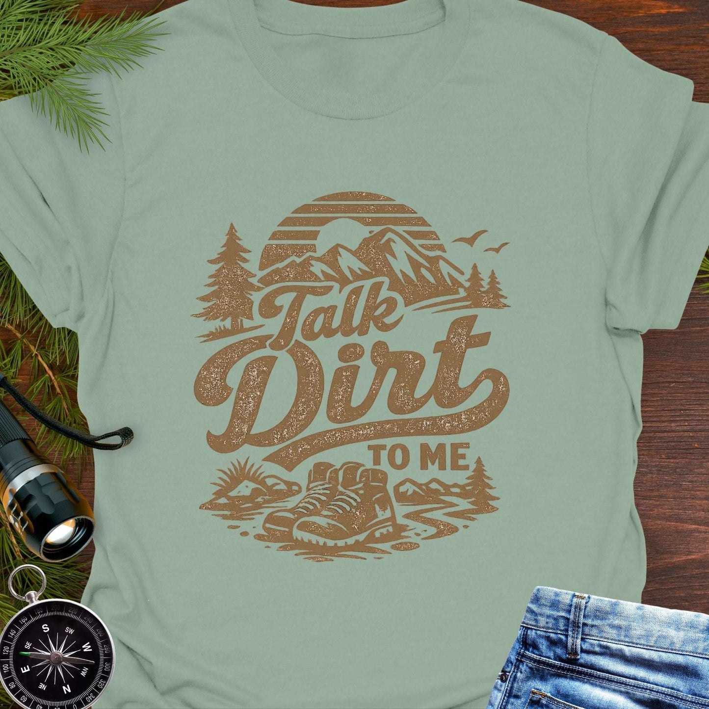 Sage green t-shirt with 'Talk Dirt to Me' graphic design with rugged mountain trail graphic—perfect for hiking, camping, and off-road lovers.