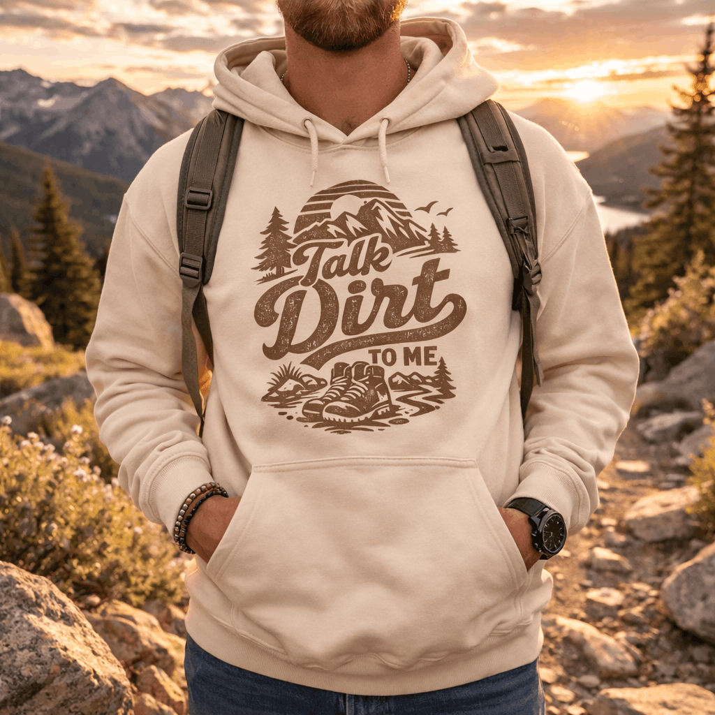 Person wearing a beige hoodie with “Talk Dirt To Me” retro mountain and hiking boots graphic, outdoor adventure pullover sweatshirt.