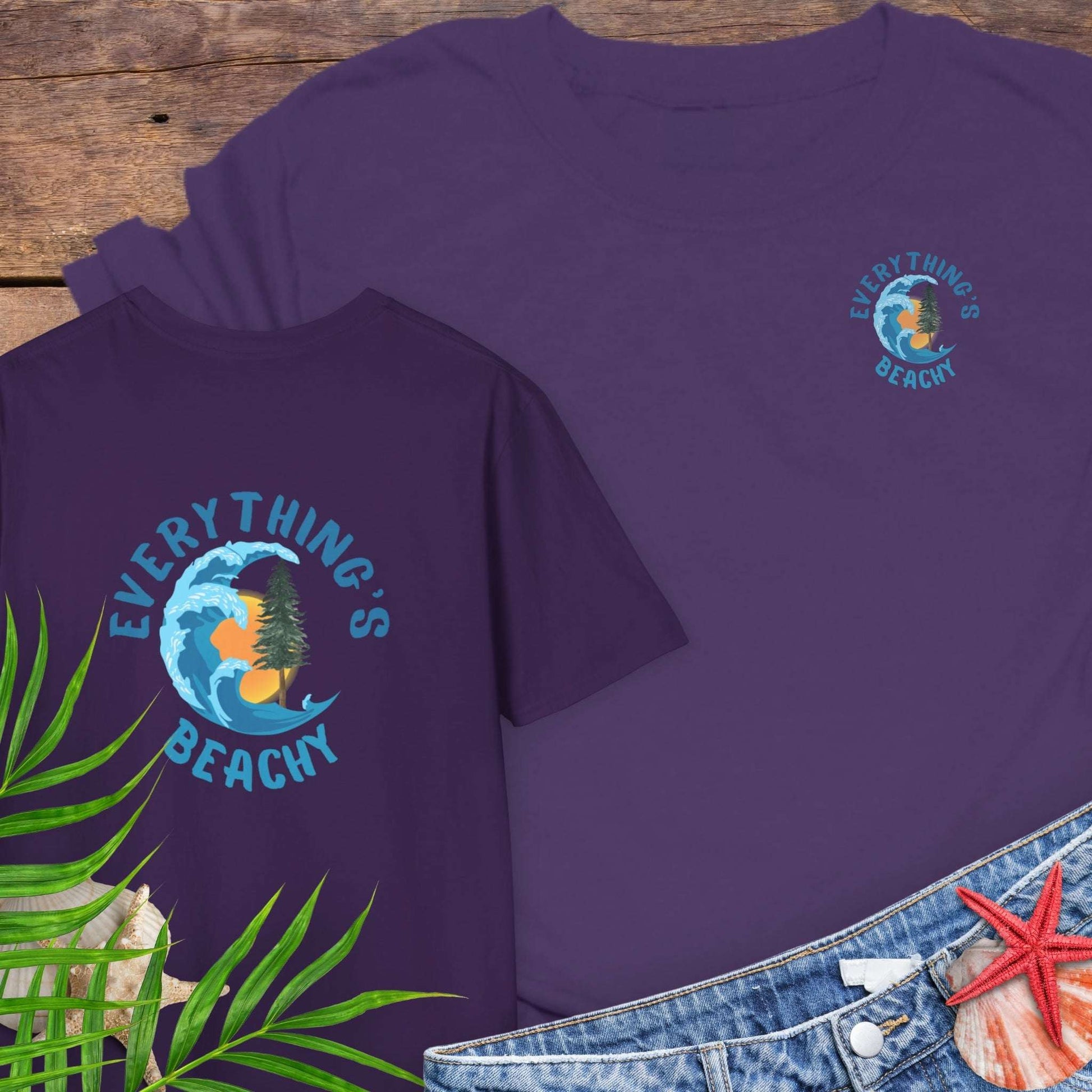 Purple t-shirt with Everything’s Beachy logo with wave, sun, and redwood graphic.