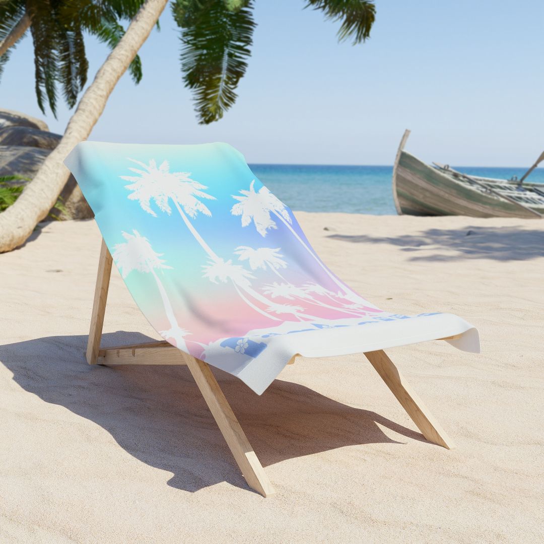 Personalized beach towel with blue-to-pink gradient, palm trees, and custom name at the bottom