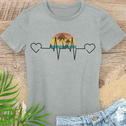 Gray t-shirt with a heart rate design featuring a sunset and palm trees on a wooden surface.