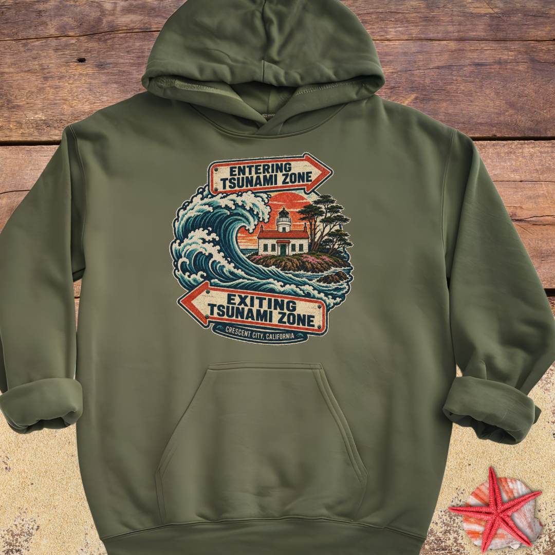 An military green Crescent City California hoodie design featuring a crashing ocean wave, coastal lighthouse, and vintage entering and exiting tsunami zone signs.
