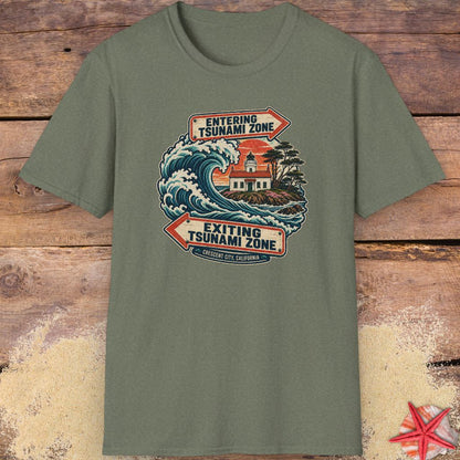 A military green Crescent City California tsunami zone T-shirt design featuring a crashing ocean wave, coastal lighthouse, and vintage entering and exiting tsunami zone signs.