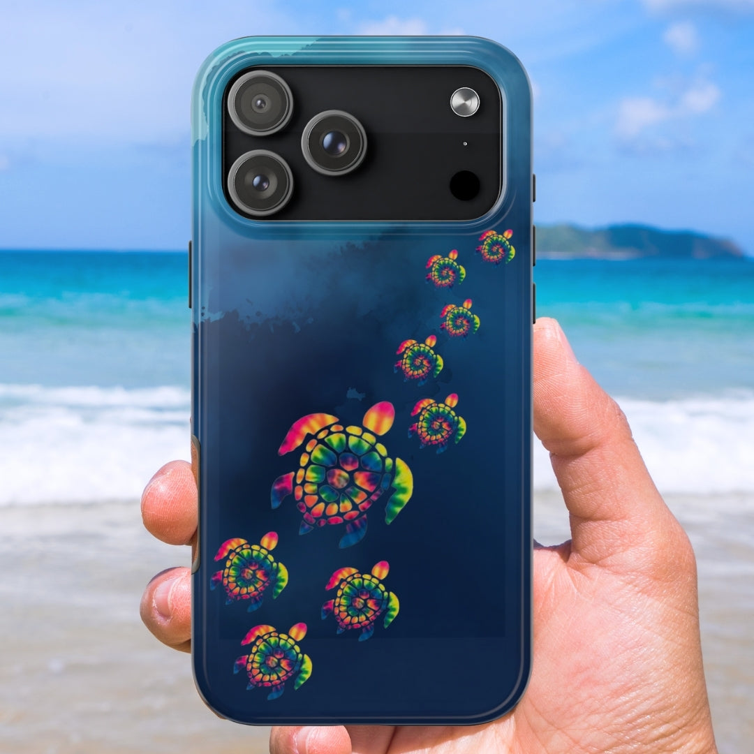 Phone case with colorful tye dye sea turtle design held by a hand on a beach