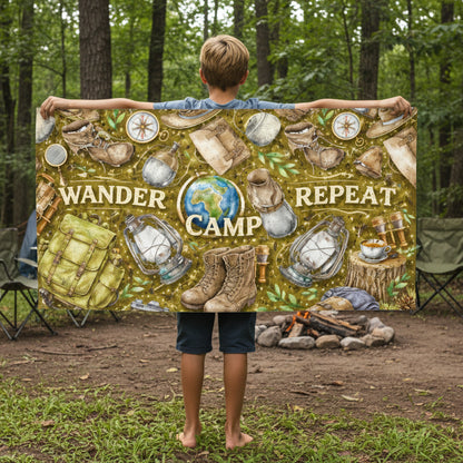 Person holding a beach towel with camping-themed design with text Wander Camp Repeat.