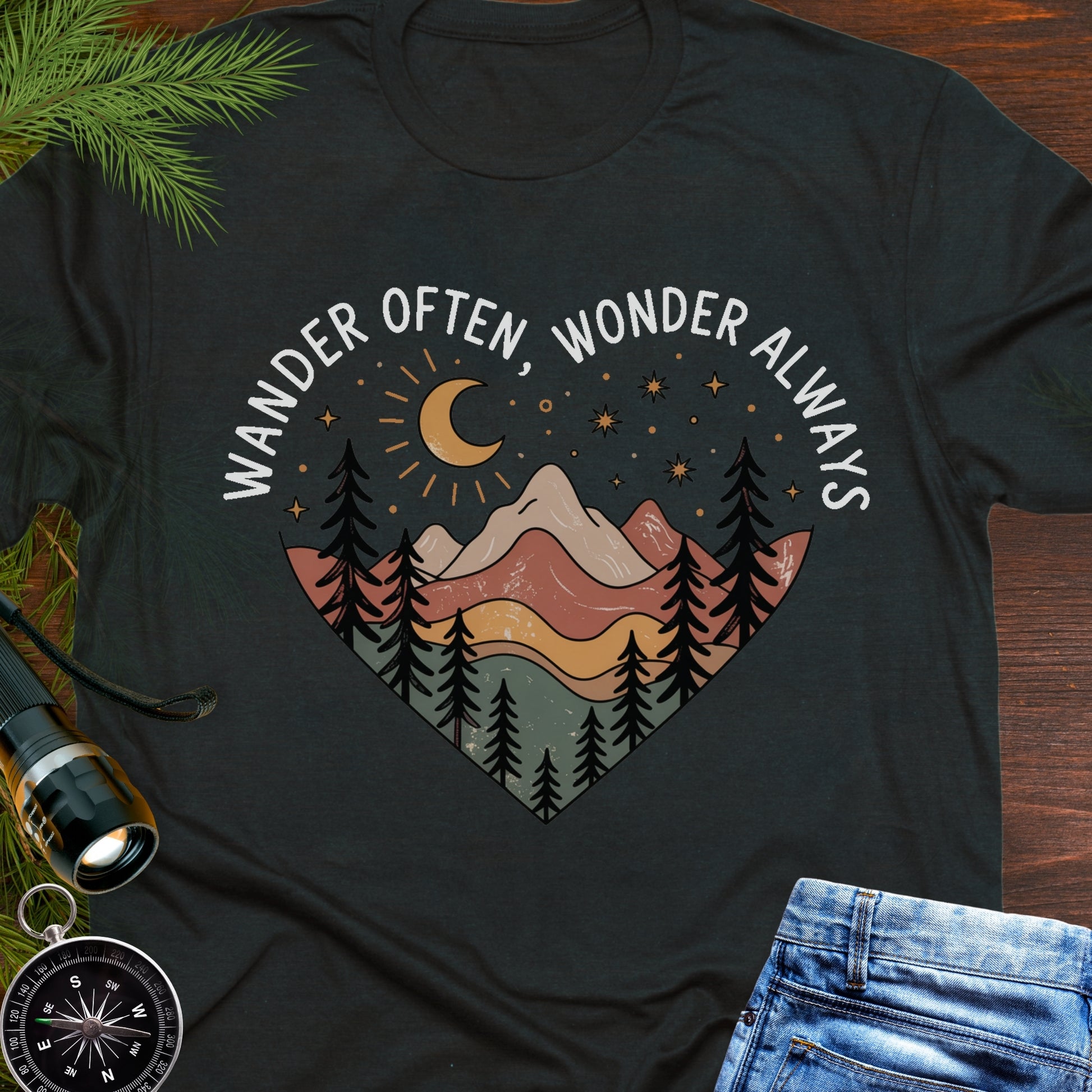 Black  Unisex t-shirt with mountain and trees in a heart shape and the phrase "Wander Often, Wonder Always".