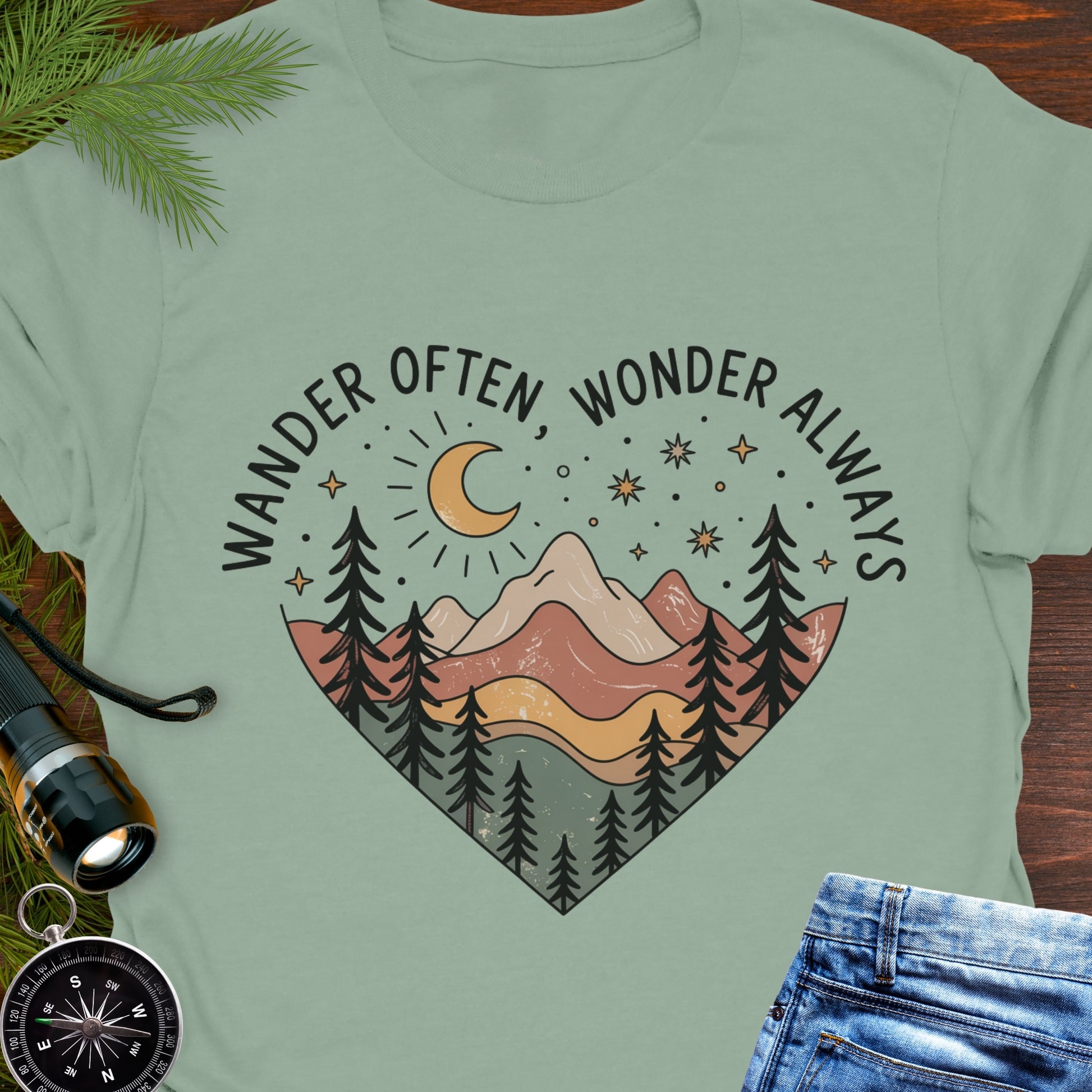 Sage Green  Unisex t-shirt with mountain and trees in a heart shape and the phrase "Wander Often, Wonder Always".