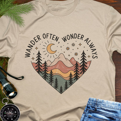 Beige  Unisex t-shirt with mountain and trees in a heart shape and the phrase "Wander Often, Wonder Always".