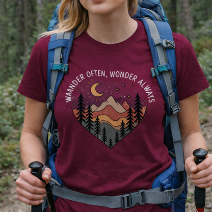 Person wearing a maroon t-shirt with nature-themed design in a heart with the text Wander Often, Wonder Always.