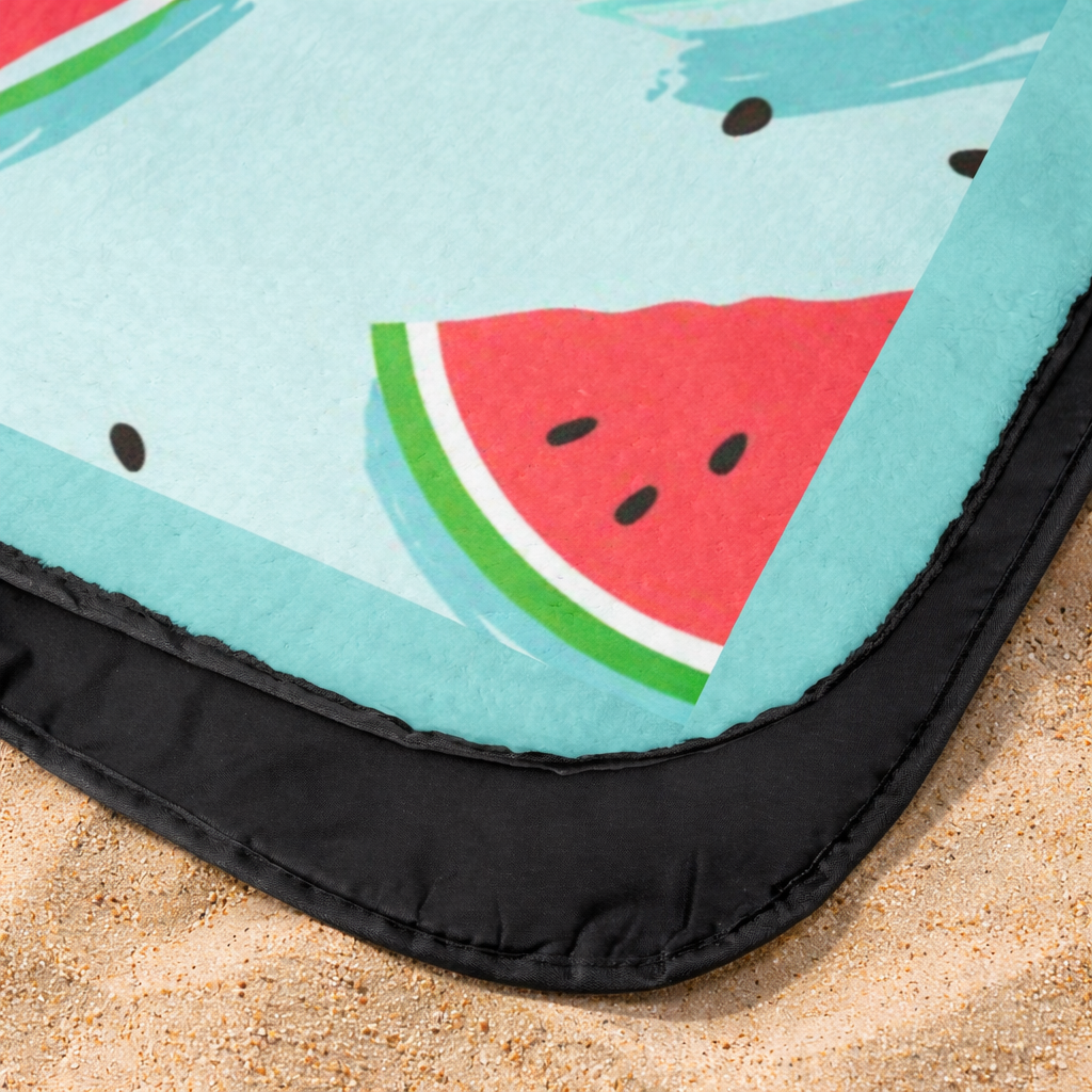 Watermelon-patterned mat on a sandy surface