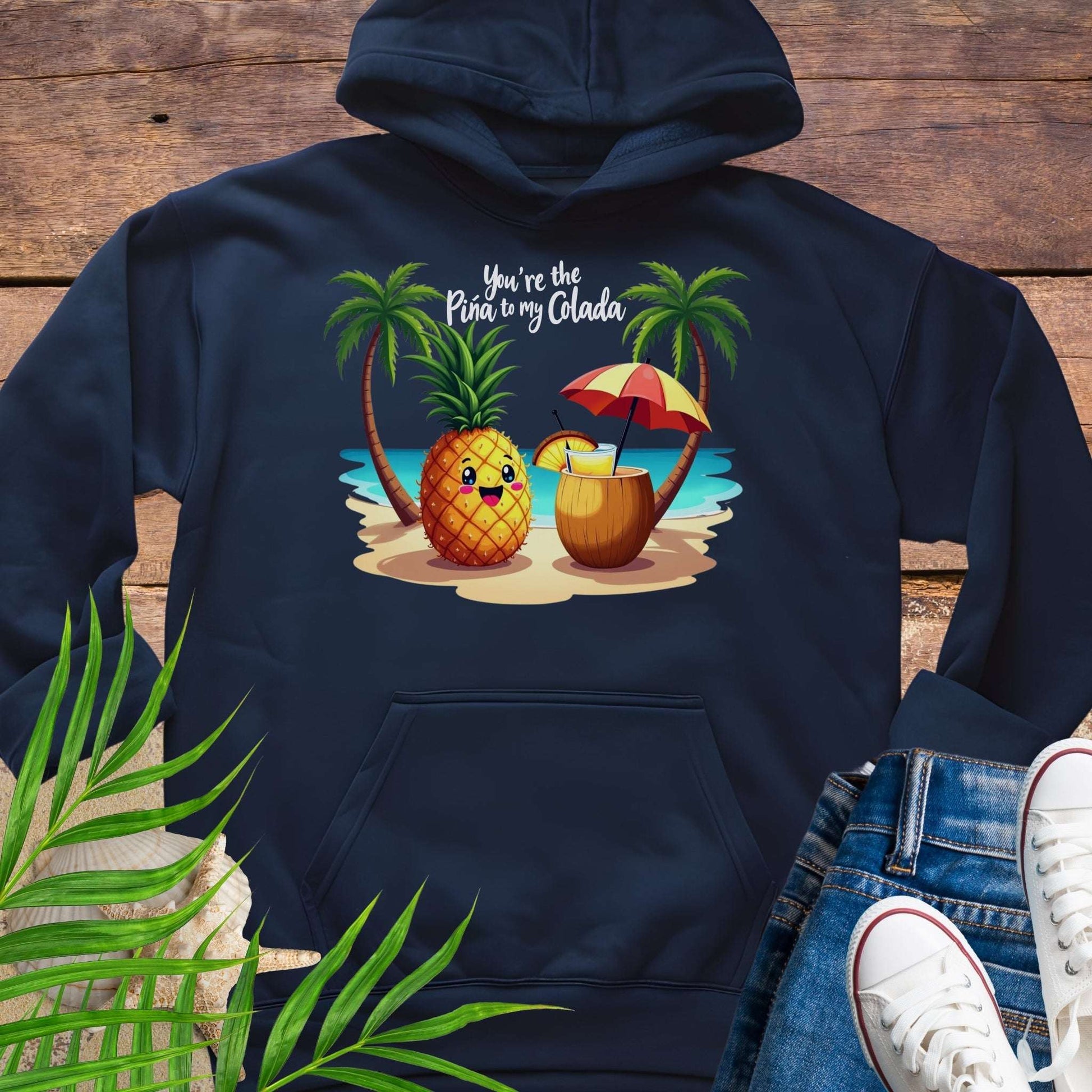 Navy blue Hoodie with a pineapple and a coconut pina colada on a beach between two palm trees with the text You're the Pina to my Colada.