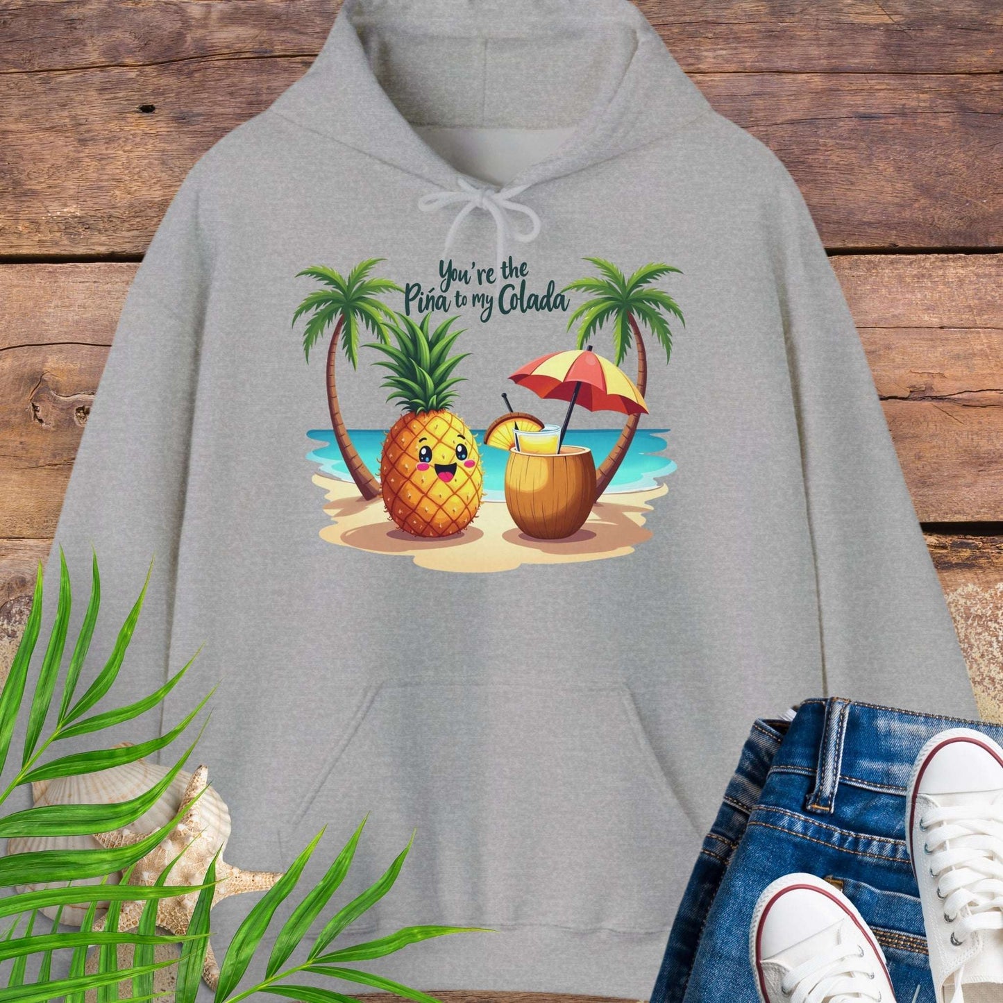 Gray Hoodie with a pineapple and a coconut pina colada on a beach between two palm trees with the text You're the Pina to my Colada.