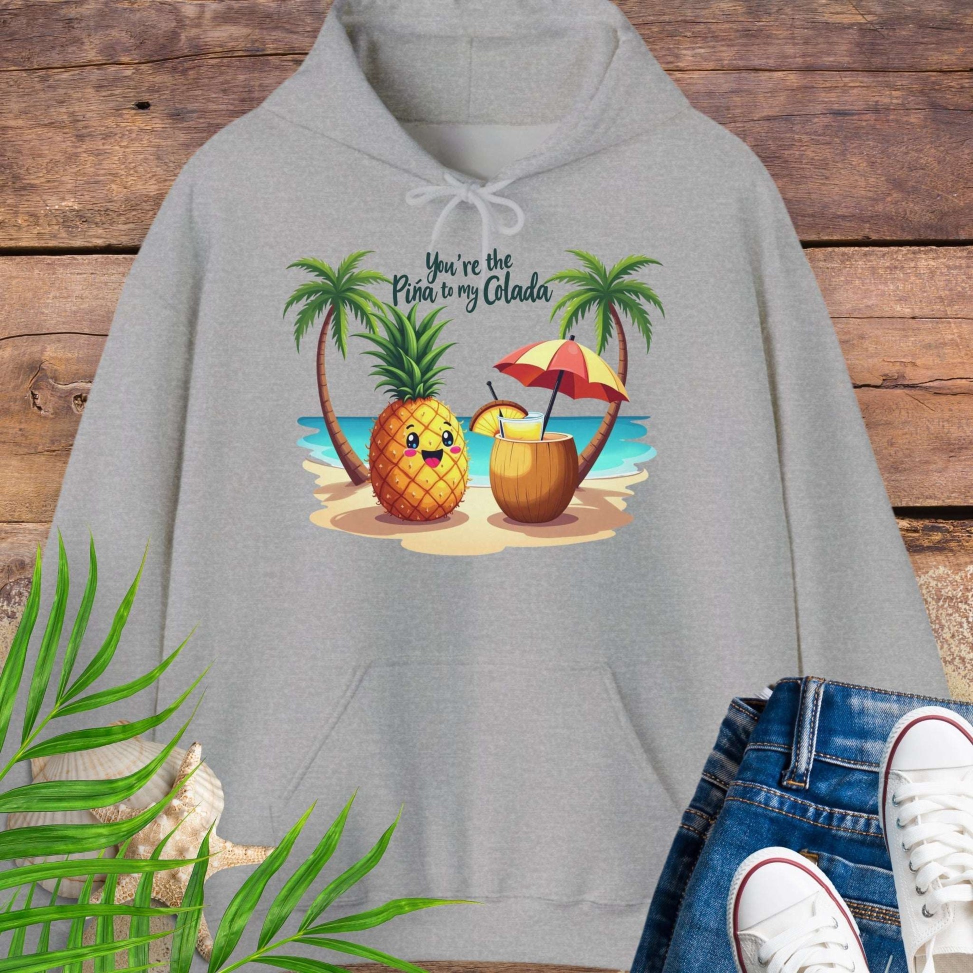 Gray Hoodie with a pineapple and a coconut pina colada on a beach between two palm trees with the text You're the Pina to my Colada.